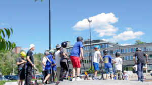 Barn och ungdomar åker kickbike på skatepark