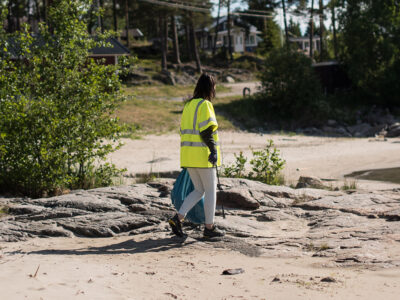 En tjej som plockar skräp på en strand