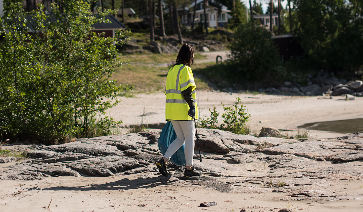 En tjej som plockar skräp på en strand